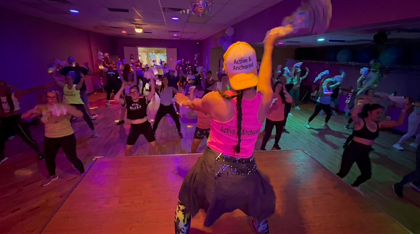 Instructor leading a high-energy dance fitness class on the Active + Anchored stage